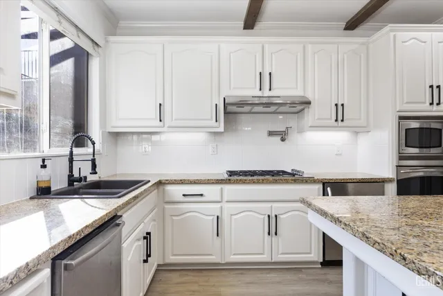 a kitchen with stainless steel appliances granite countertop a sink stove cabinets and wooden floor