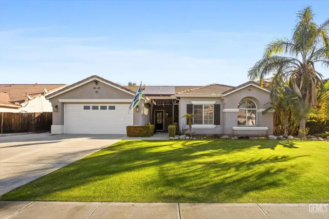 a view of a house with a big yard and large trees