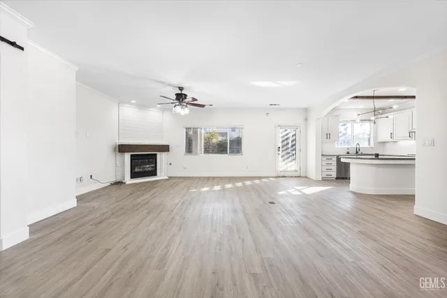 an empty room with wooden floor and fireplace