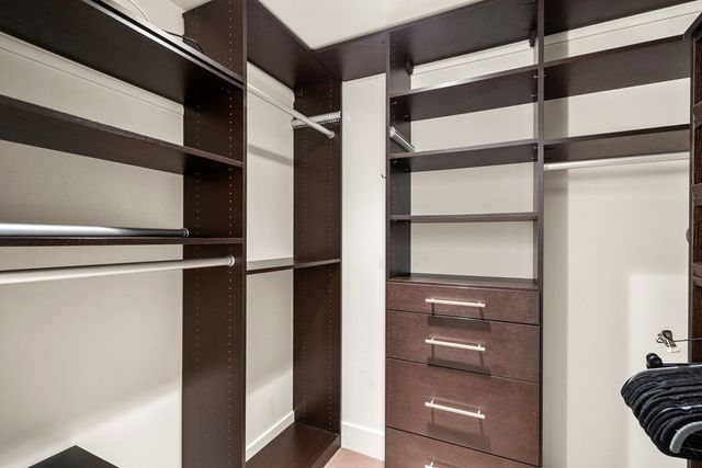 a view of walk in closet with empty racks