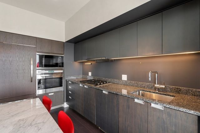 a kitchen with stainless steel appliances granite countertop a sink a stove and cabinets