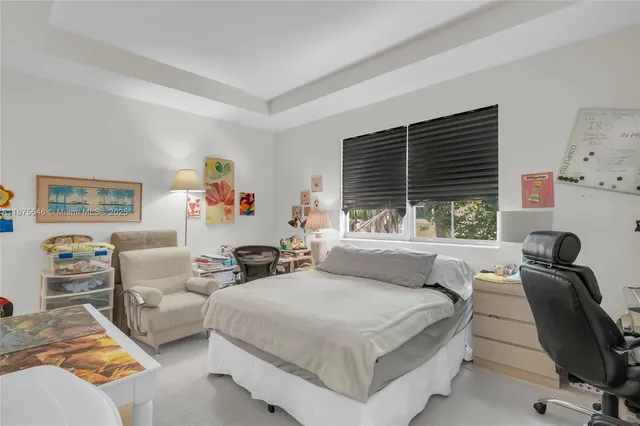 a bedroom with furniture and a large window