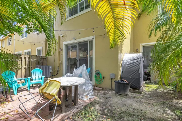 a view of a patio with table and chairs potted plants and palm tree
