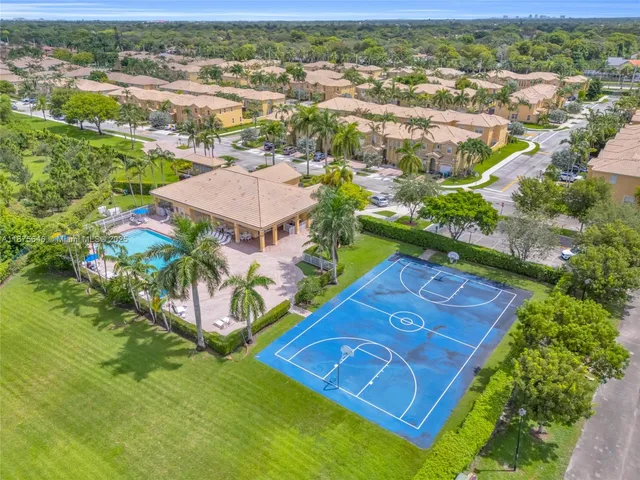 an aerial view of residential houses with outdoor space and parking