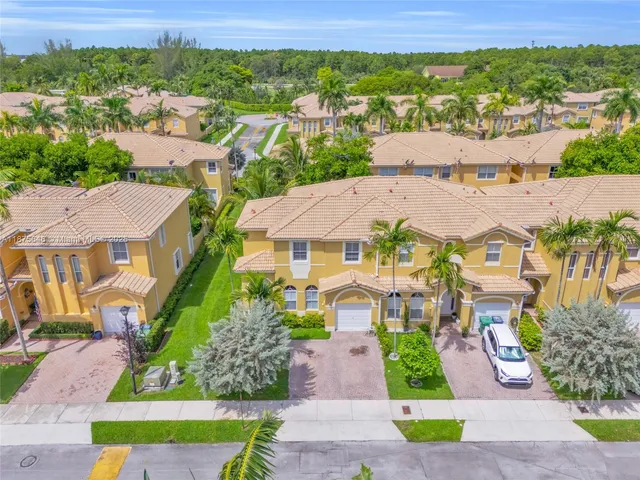 an aerial view of residential houses with outdoor space and street view