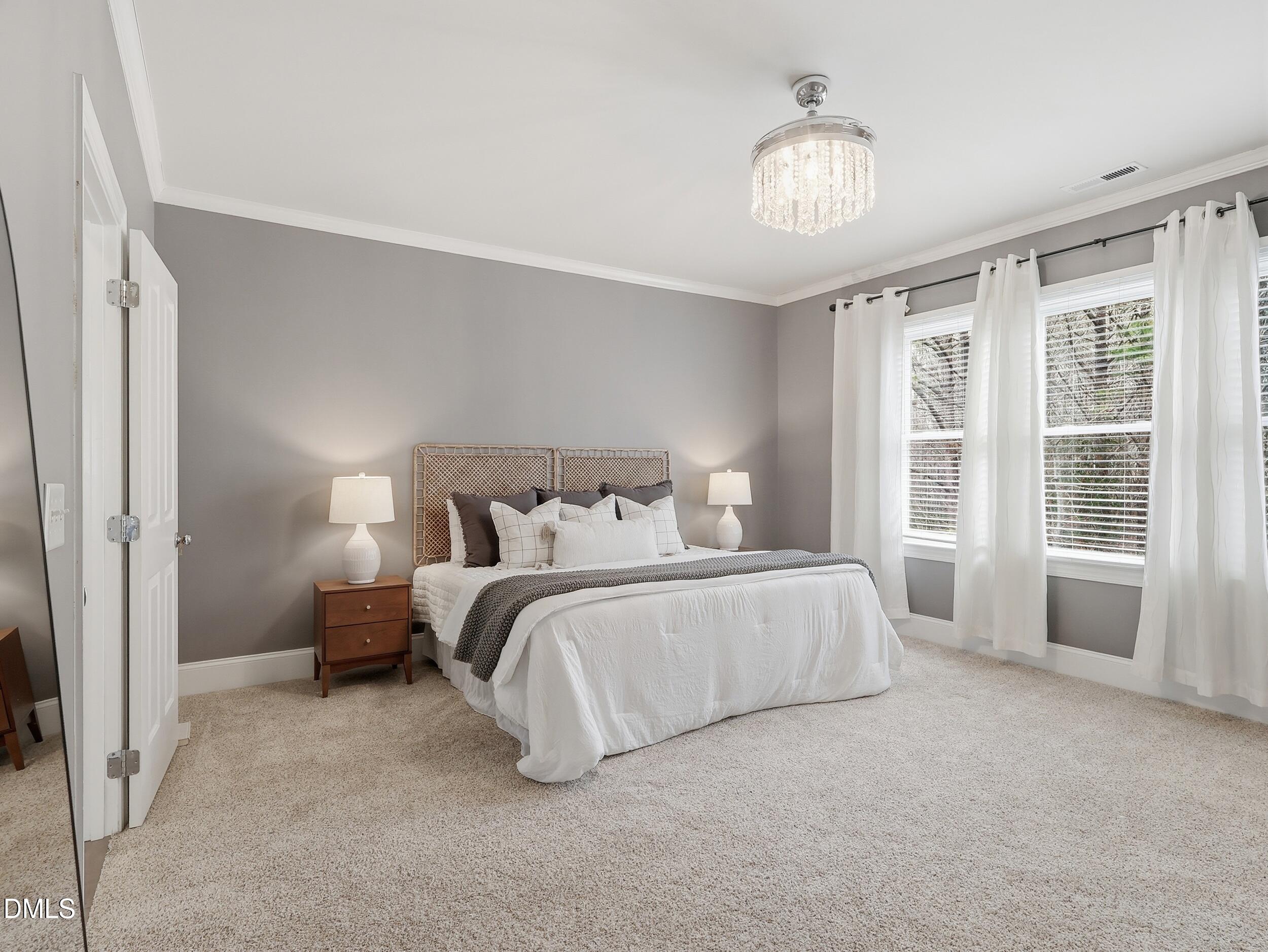 208 Brookberry Road Holly Springs, NC 27540 - Photo 11 of 32 a spacious bedroom with a bed and a chandelier