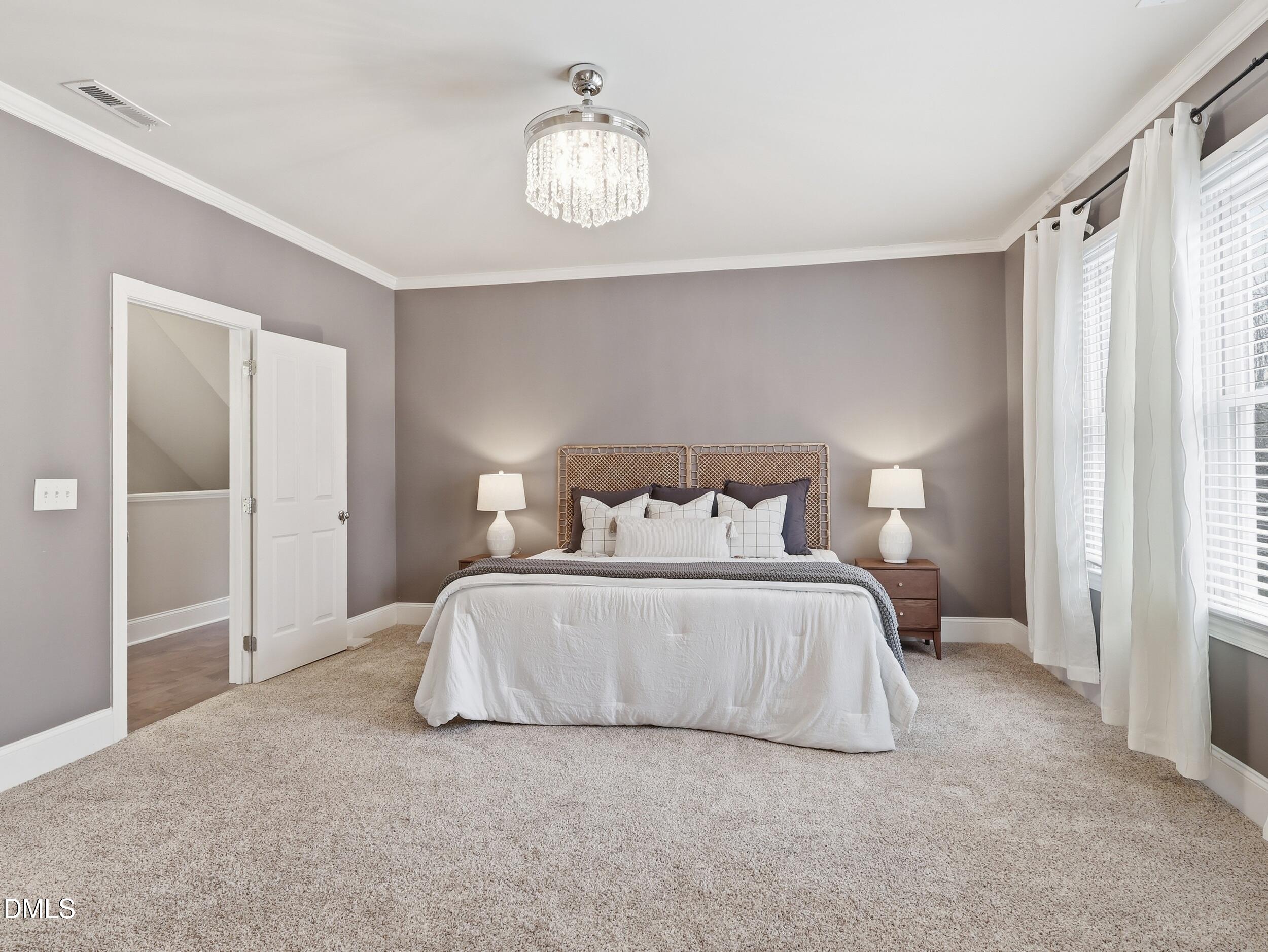 208 Brookberry Road Holly Springs, NC 27540 - Photo 12 of 32 a bedroom with a bed and a chandelier