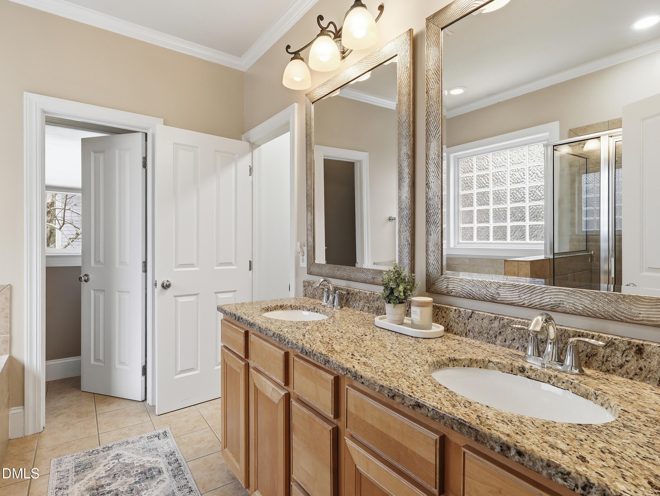 208 Brookberry Road Holly Springs, NC 27540 - Photo 13 of 32 a bathroom with a granite countertop double vanity sink a mirror and a shower