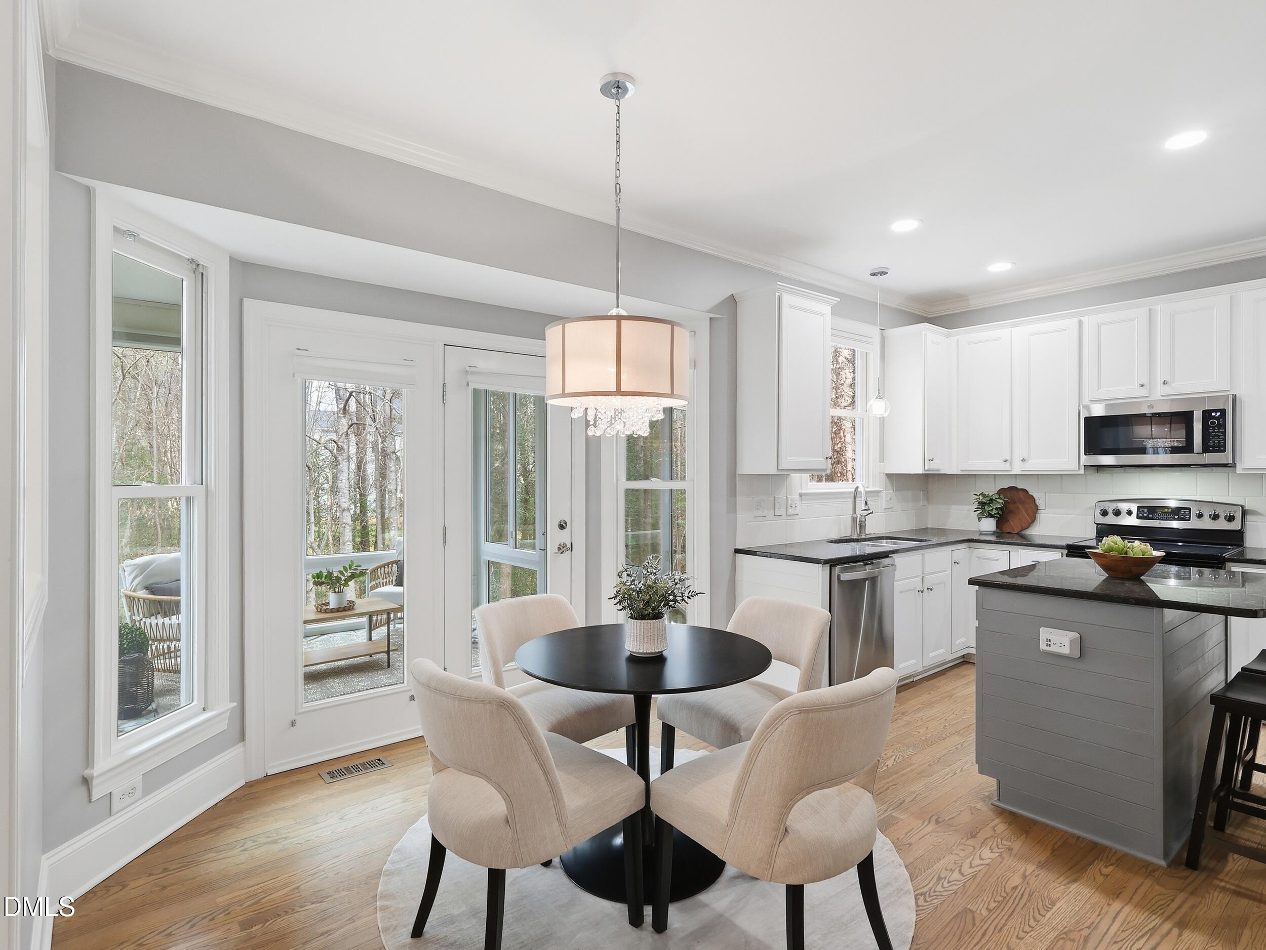 208 Brookberry Road Holly Springs, NC 27540 - Photo 7 of 32 a kitchen with stainless steel appliances granite countertop a stove a sink a microwave a dining table and chairs