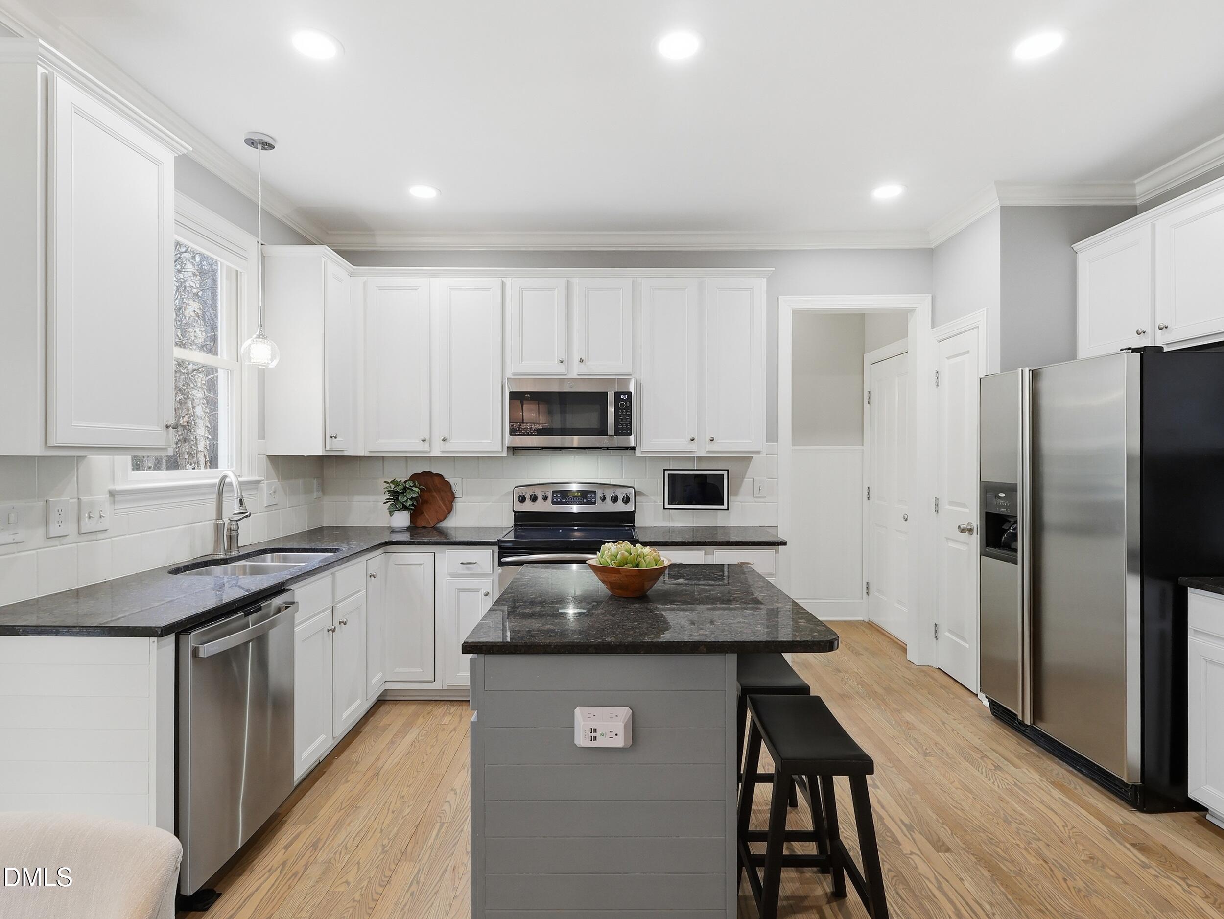 208 Brookberry Road Holly Springs, NC 27540 - Photo 8 of 32 a kitchen with stainless steel appliances granite countertop a refrigerator a stove top oven a sink dishwasher and wooden cabinets