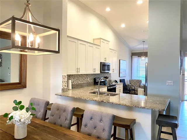 a kitchen with granite countertop a sink a counter top space and living room view