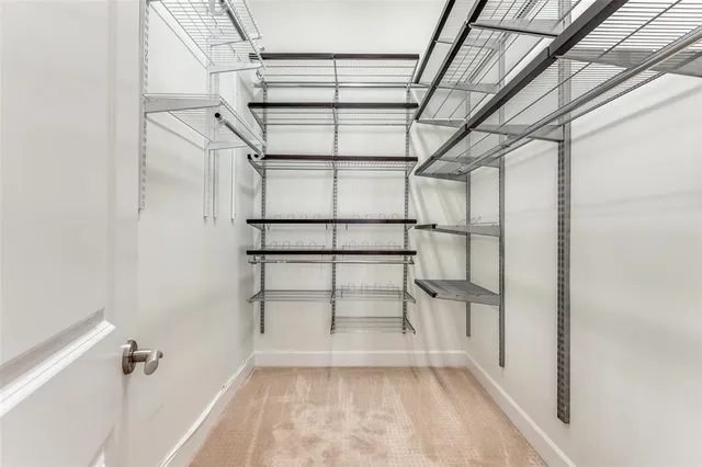 a view of walk in closet with empty racks