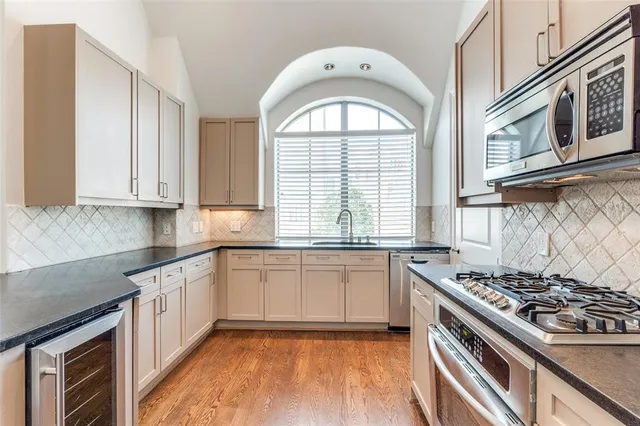 a kitchen with stainless steel appliances granite countertop a stove a sink and a white cabinets