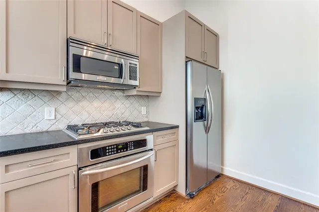 a kitchen with granite countertop cabinets stainless steel appliances and wooden floor