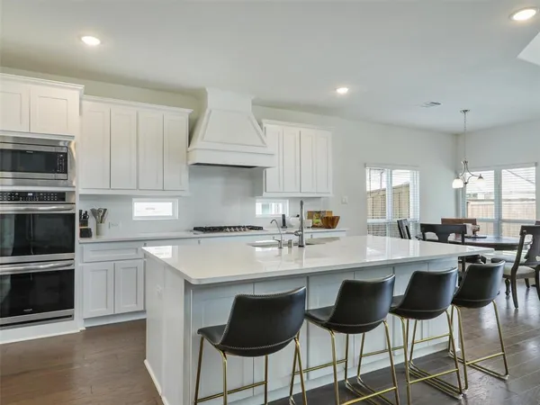 a kitchen with kitchen island granite countertop a sink counter and chairs