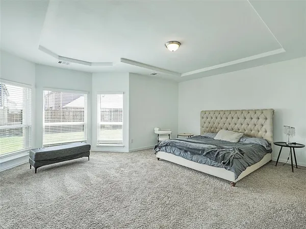 a spacious bedroom with a bed a table and large window