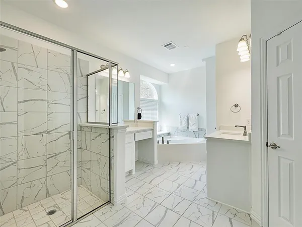 a bathroom with a shower a sink and a mirror