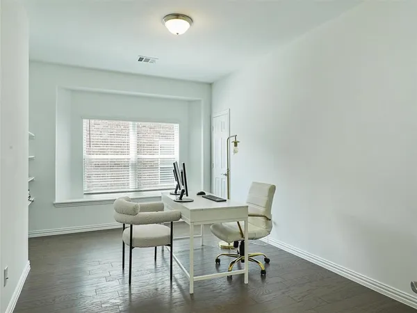 a view of a workspace with furniture and a window