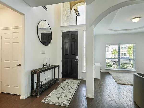 a view of a hallway with entryway wooden floor and front door