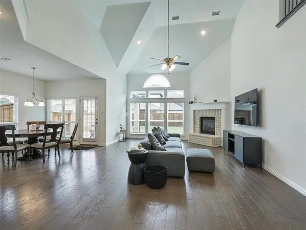 a living room with furniture large window and kitchen view