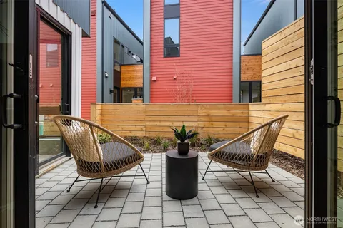 a living room with stainless steel appliances kitchen island granite countertop furniture and a wooden floor