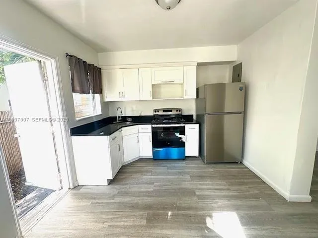 a view of a room with wooden floor and a window