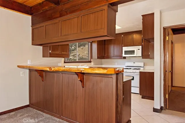 a kitchen with stainless steel appliances granite countertop a refrigerator a sink and wooden cabinets
