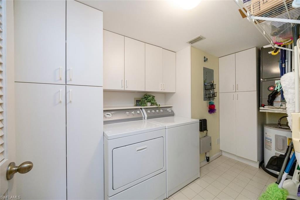 5980 Amherst Drive, Unit D202 Naples, FL 34112 - Photo 12 of 12 Clothes washing area featuring light tile patterned floors, cabinet space, visible vents, and washer and dryer