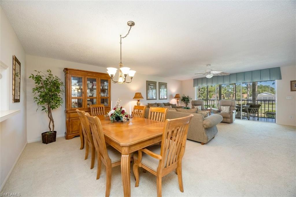 5980 Amherst Drive, Unit D202 Naples, FL 34112 - Photo 6 of 12 Dining space with baseboards, ceiling fan with notable chandelier, and light carpet