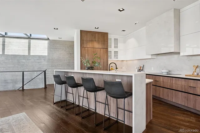 a kitchen with stainless steel appliances kitchen island granite countertop a table chairs in it and wooden floors