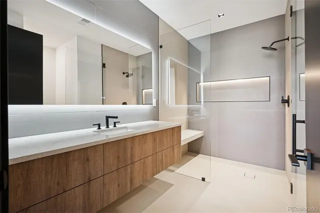 a bathroom with a double vanity sink toilet mirror and shower