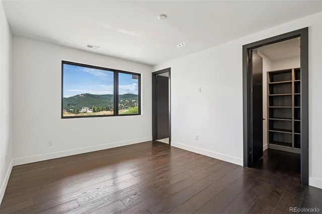 an empty room with wooden floor and window