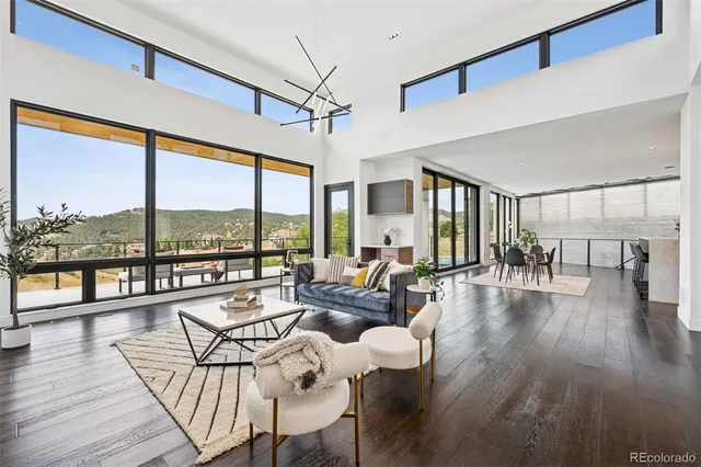 a living room with furniture and a large window with wooden floor