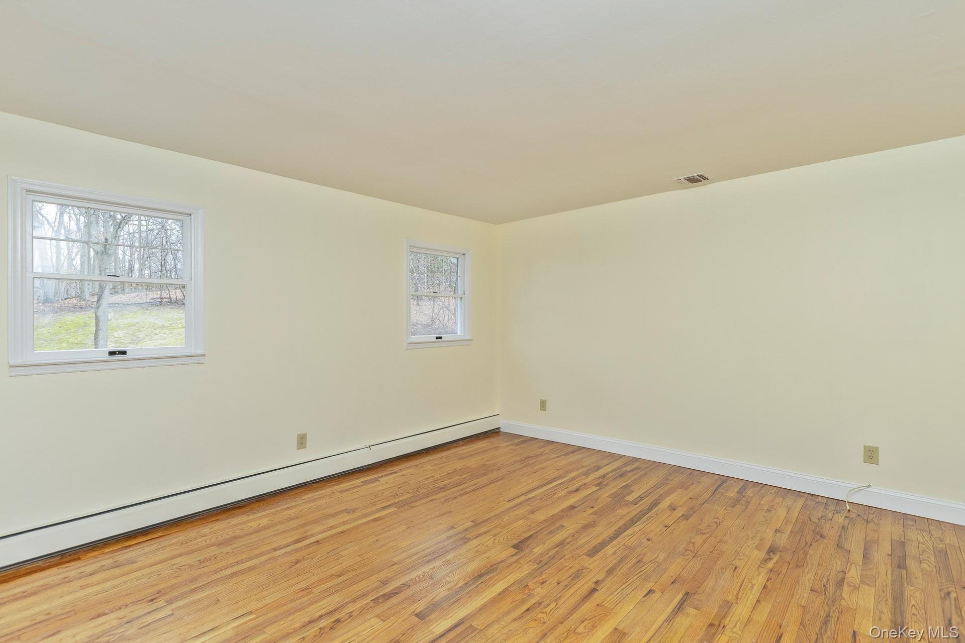451 River Road Nissequogue, NY 11780 - Photo 20 of 24 an empty room with wooden floor and windows