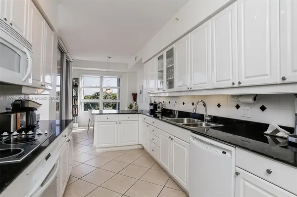 a kitchen with granite countertop white cabinets and black appliances