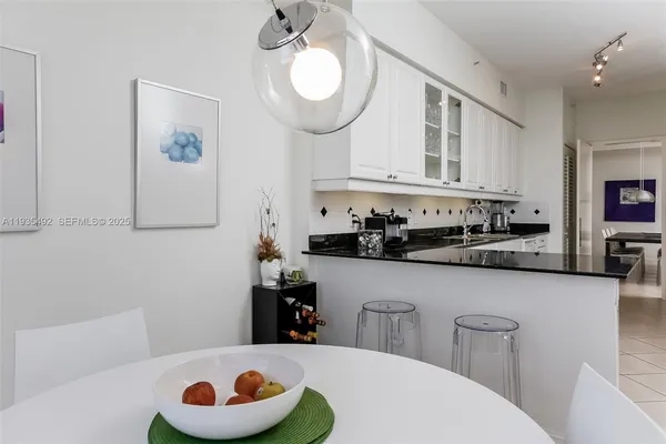 a kitchen with stainless steel appliances granite countertop a sink a stove and white cabinets