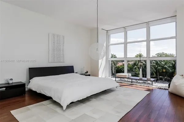 a bedroom with a bed and a large window