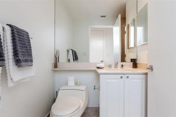 a bathroom with a toilet a sink and mirror