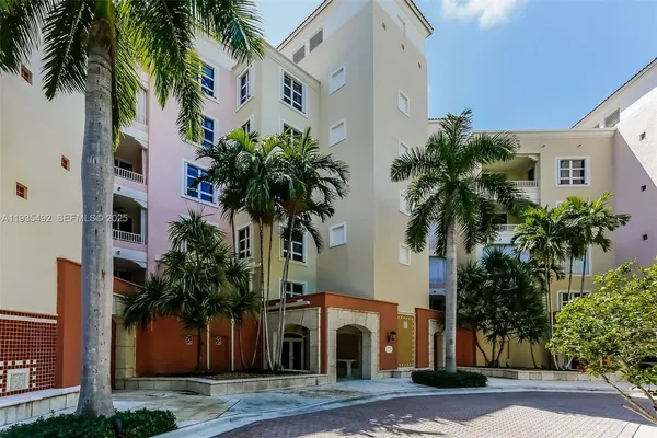 a front view of multiple houses with palm trees