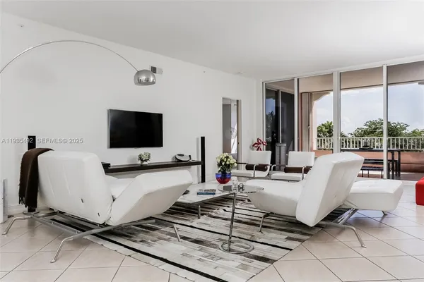 a living room with patio furniture and a flat screen tv