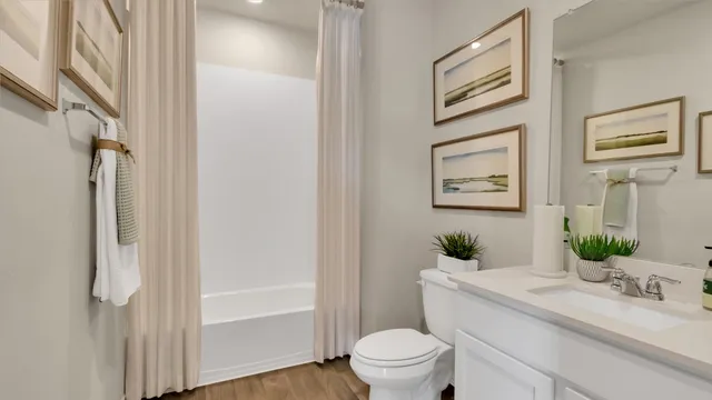 a bathroom with a granite countertop sink mirror vanity and toilet