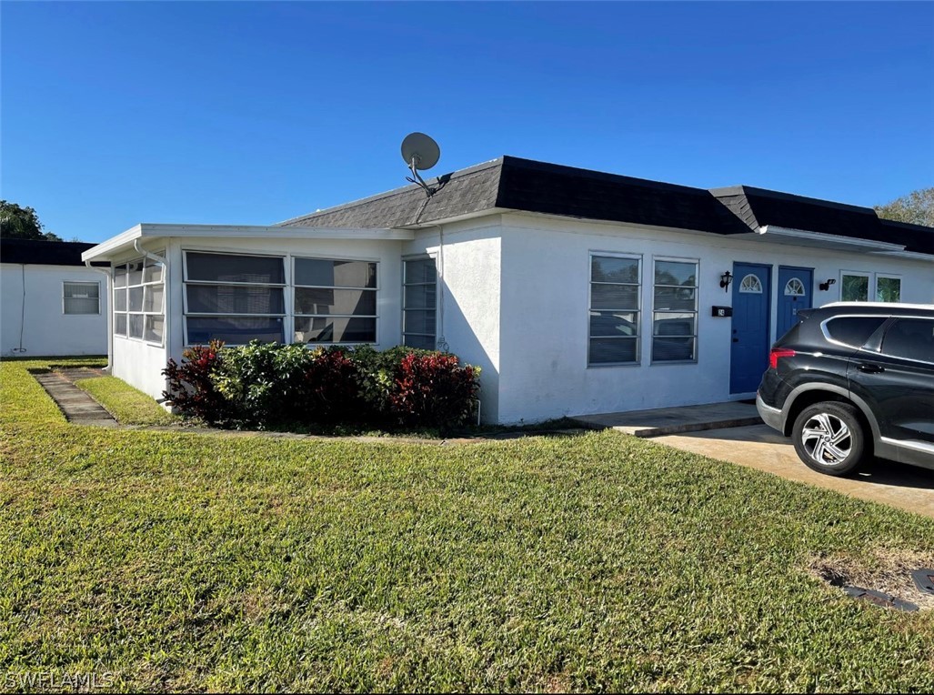 a view of a house with a big yard and potted plants