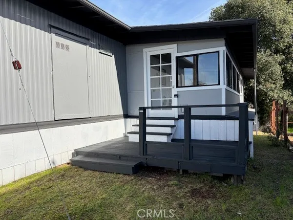 a view of backyard with deck and wooden fence