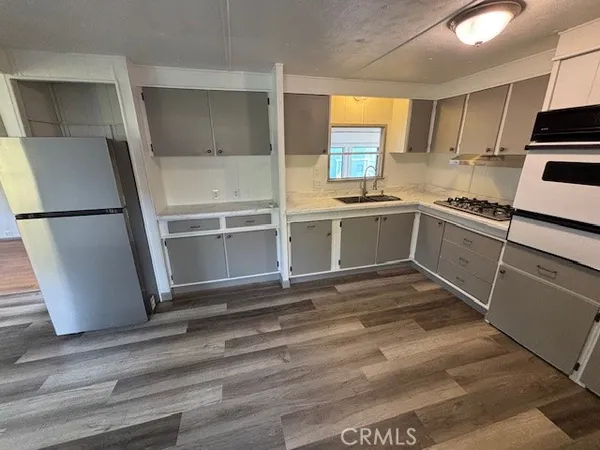 a kitchen with granite countertop a refrigerator and a stove top oven