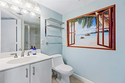 a bathroom with a sink mirror and toilet