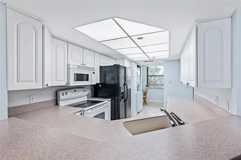 a kitchen with stainless steel appliances a refrigerator sink and cabinets
