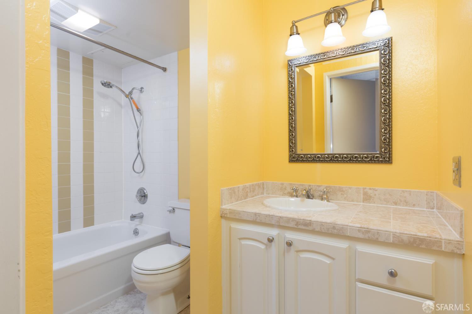1 Kelton Court, Unit 1E Oakland, CA 94611 - Photo 12 of 23 a bathroom with a granite countertop sink toilet and shower