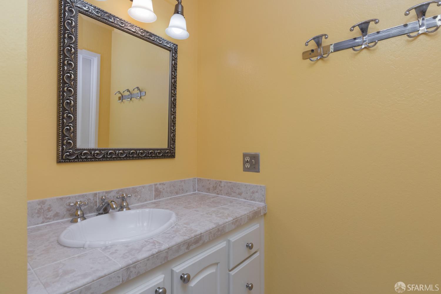 1 Kelton Court, Unit 1E Oakland, CA 94611 - Photo 13 of 23 a bathroom with a granite countertop sink and a mirror