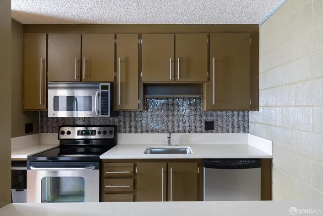 a kitchen with stainless steel appliances a stove a sink and a microwave