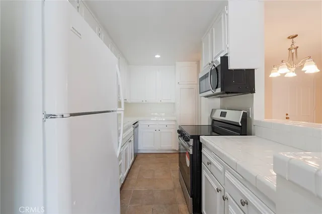 a kitchen with a refrigerator and a stove top oven